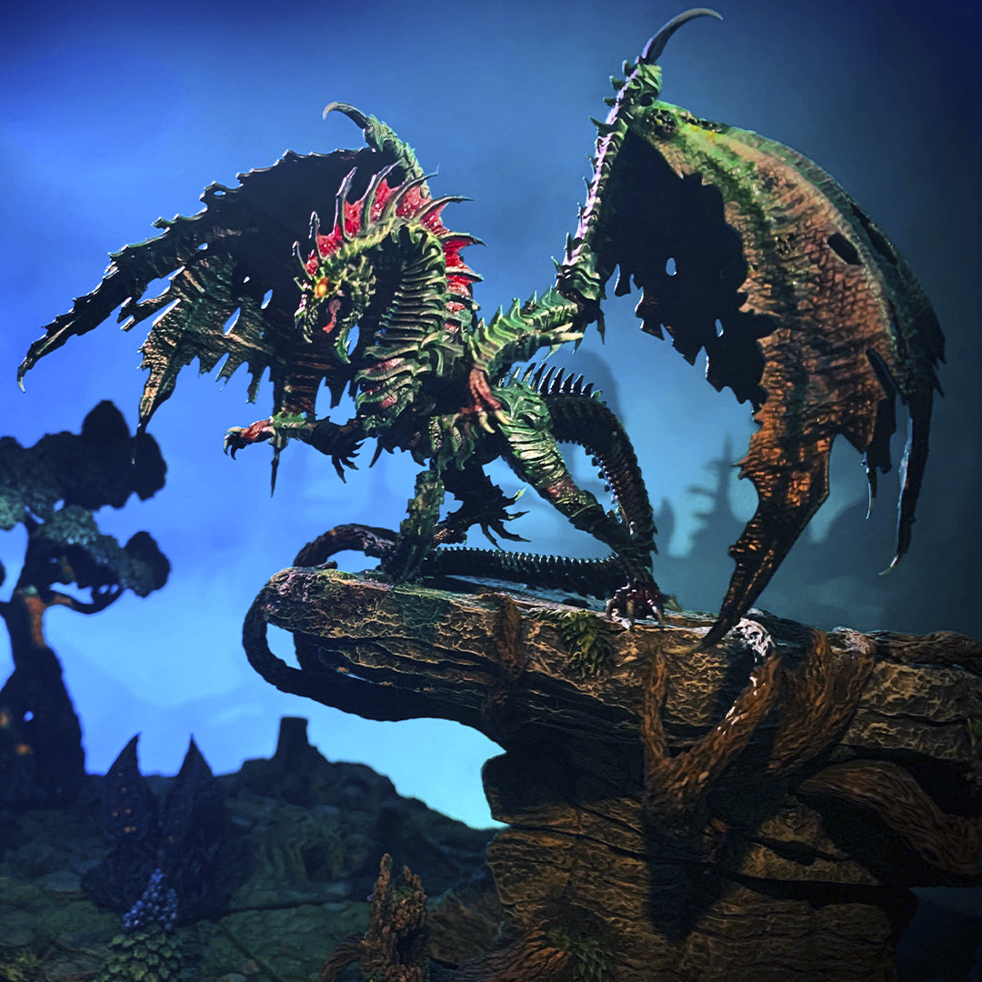 the Vencurra Dragon stands upon a rock ledge and overlooks their domain below