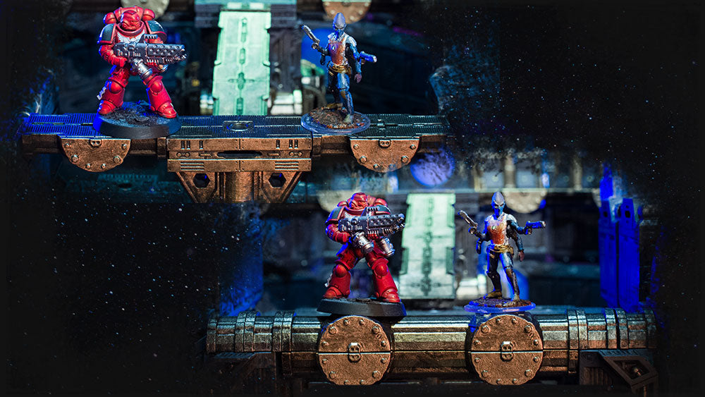 Tow different sized miniatures standing atop a catwalk and the same two figured standing atop a pipeline.